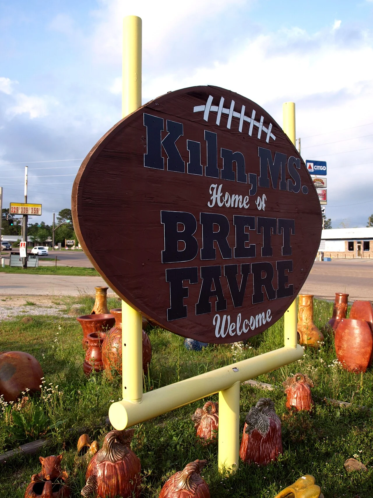 A football-shaped sign reading Kiln, Home of Brett Favre, Welcome
